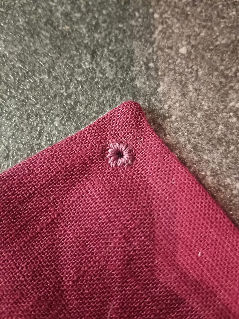 Nahaufnahme einer handgestickten Öse